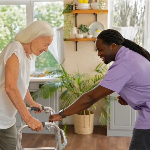 Woman using walker being helped by man.